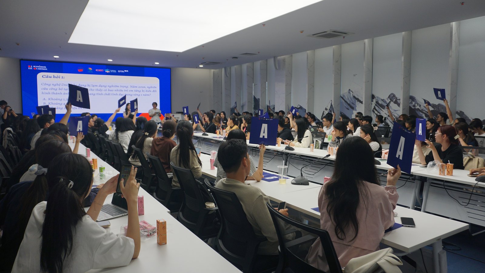 Sinh viên sôi nổi tranh luận và đồng loạt giơ bảng phương án trong minigame thử thách kiểm chứng tin giả, vạch trần các thủ đoạn lợi dụng công nghệ Deepfake tinh vi. Ảnh: BTC.
